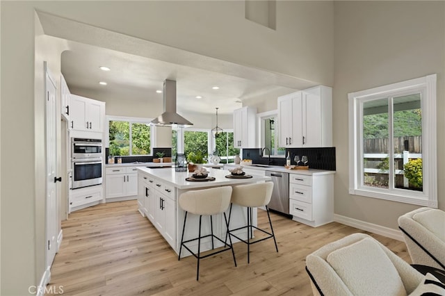 44240 La Cruz Dr, Temecula, CA 92590 - kitchen featuring a sink, stainless steel appliances, tasteful backsplash, island exhaust hood, and a breakfast bar