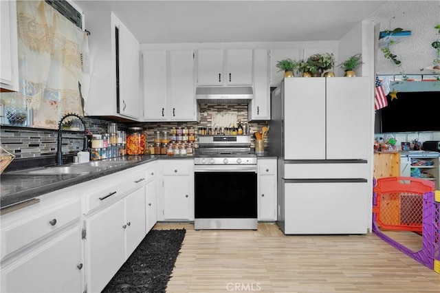 9546 Verdugo Ave, Hesperia, CA 92345 - kitchen featuring a sink, freestanding refrigerator, under cabinet range hood, stainless steel range, and decorative backsplash