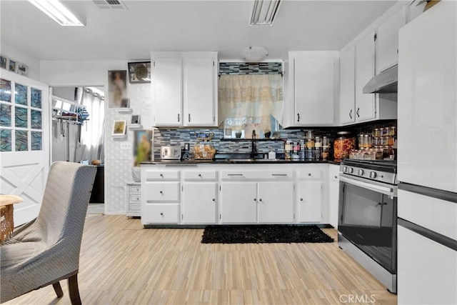 9546 Verdugo Ave, Hesperia, CA 92345 - kitchen with freestanding refrigerator, under cabinet range hood, a sink, stainless steel range with gas stovetop, and dark countertops