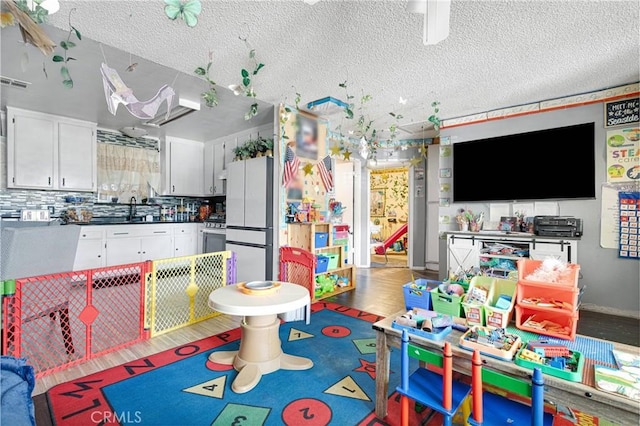 9546 Verdugo Ave, Hesperia, CA 92345 - playroom featuring a textured ceiling, visible vents, and a sink