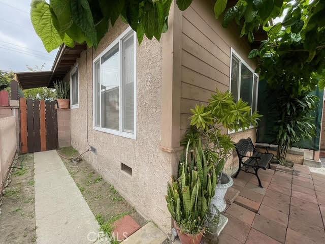 view of property exterior with fence, a patio, stucco siding, and crawl space