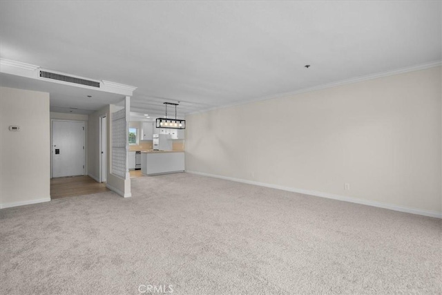 unfurnished living room featuring baseboards, ornamental molding, visible vents, and light colored carpet