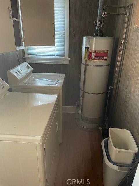 laundry room with washing machine and dryer, water heater, laundry area, and dark wood finished floors