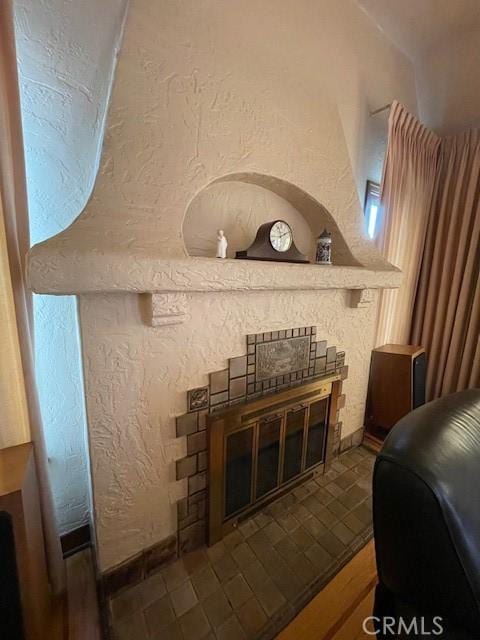 details with a glass covered fireplace and a textured wall