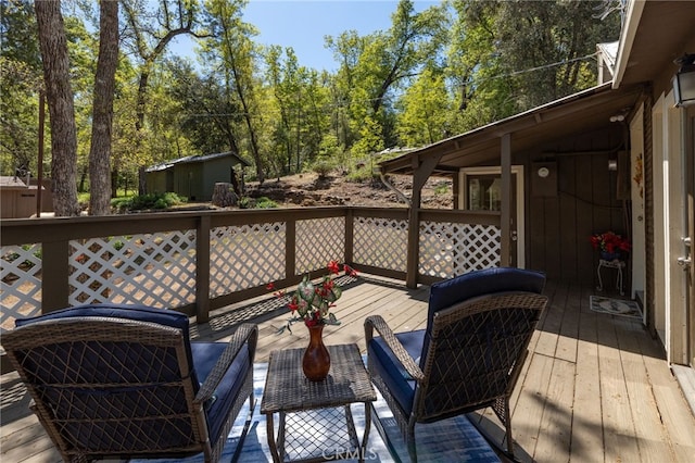 wooden terrace featuring an outbuilding and a storage unit