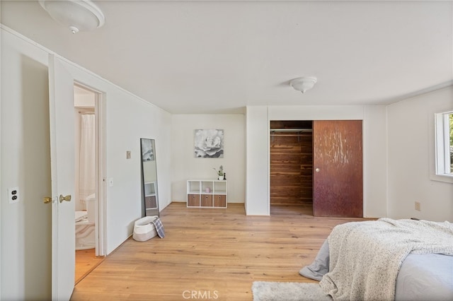 bedroom with light wood finished floors and a closet