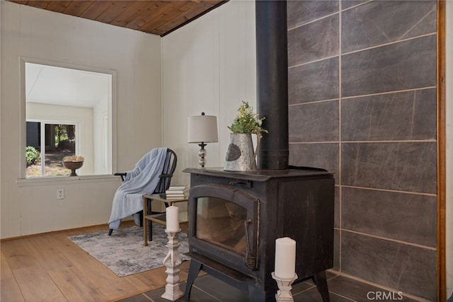 living area with a wood stove, wood-type flooring, and wood ceiling