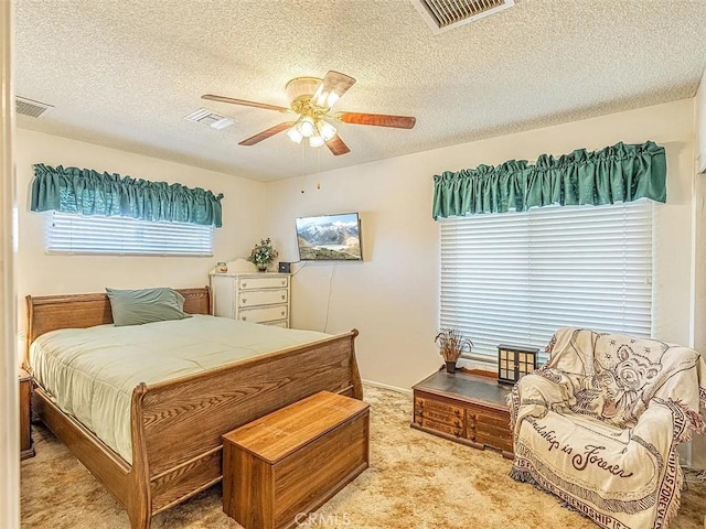 bedroom featuring carpet, visible vents, and a textured ceiling