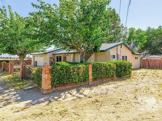 view of front of property featuring fence, a garage, and stucco siding