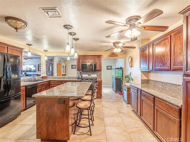 44315 88th St E, Lancaster, CA 93535 - kitchen featuring a ceiling fan, a textured ceiling, visible vents, a kitchen bar, and black appliances