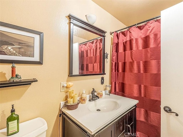 full bath featuring toilet, curtained shower, and vanity