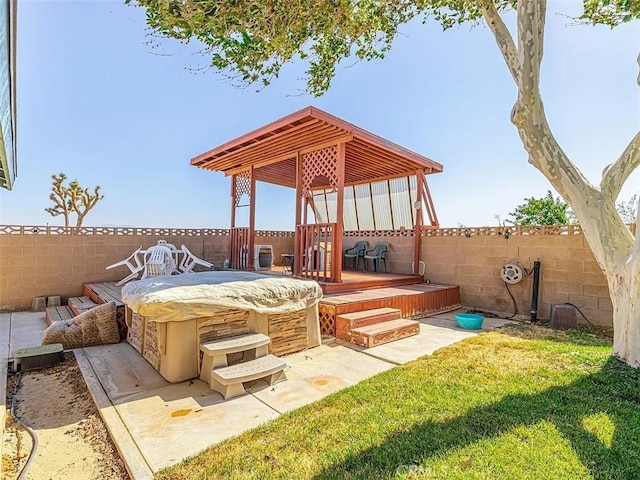 view of patio with a gazebo, a hot tub, a deck, and a fenced backyard