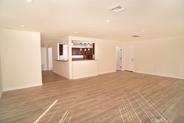 44315 88th St E, Lancaster, CA 93535 - unfurnished living room featuring recessed lighting, light wood-style floors, baseboards, and a sink