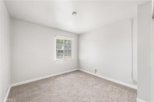 carpeted spare room with baseboards
