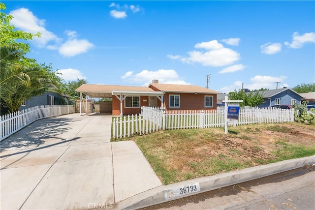 view of front of home featuring a fenced front yard, driveway, and an attached carport