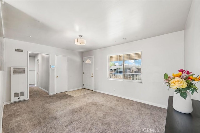 interior space featuring baseboards, a heating unit, and visible vents