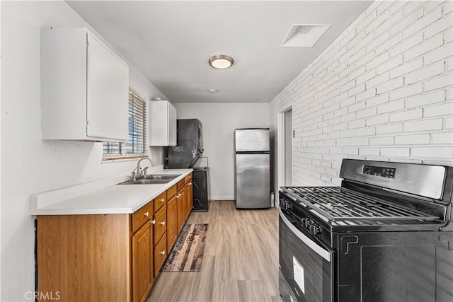 kitchen featuring a sink, brown cabinetry, stainless steel appliances, visible vents, and light countertops