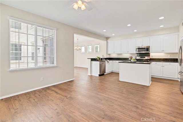 39992 Pasadena Dr, Temecula, CA 92591 - kitchen featuring stainless steel appliances, dark countertops, white cabinets, light wood-style floors, and a ceiling fan