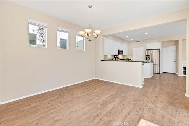 39992 Pasadena Dr, Temecula, CA 92591 - kitchen featuring stainless steel appliances, a chandelier, dark countertops, white cabinets, and light wood-type flooring
