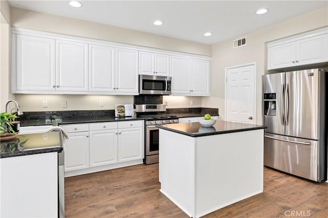 39992 Pasadena Dr, Temecula, CA 92591 - kitchen with appliances with stainless steel finishes, white cabinets, a sink, recessed lighting, and wood finished floors