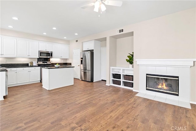 39992 Pasadena Dr, Temecula, CA 92591 - kitchen featuring appliances with stainless steel finishes, ceiling fan, white cabinetry, a kitchen island, and light wood-type flooring