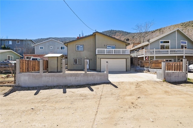 3516 Illinois Trl, Frazier Park, CA 93225 - back of property with a mountain view, a balcony, driveway, a garage, and a fenced front yard