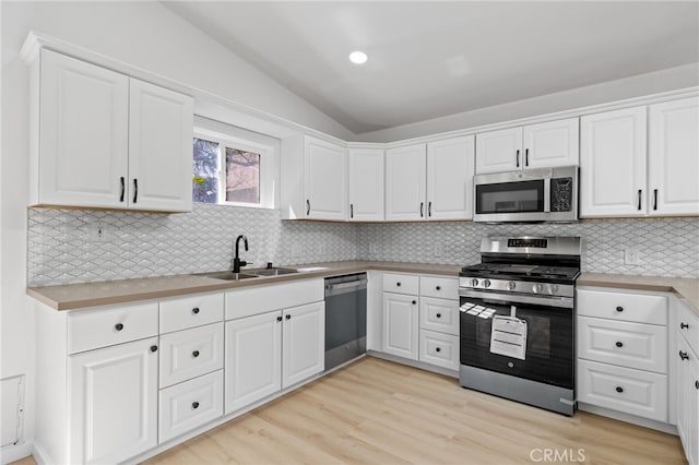 3516 Illinois Trl, Frazier Park, CA 93225 - kitchen featuring a sink, vaulted ceiling, light countertops, white cabinets, and appliances with stainless steel finishes