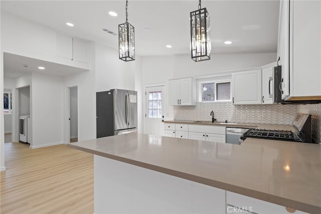 3516 Illinois Trl, Frazier Park, CA 93225 - kitchen with a sink, a peninsula, stainless steel appliances, tasteful backsplash, and light wood-type flooring