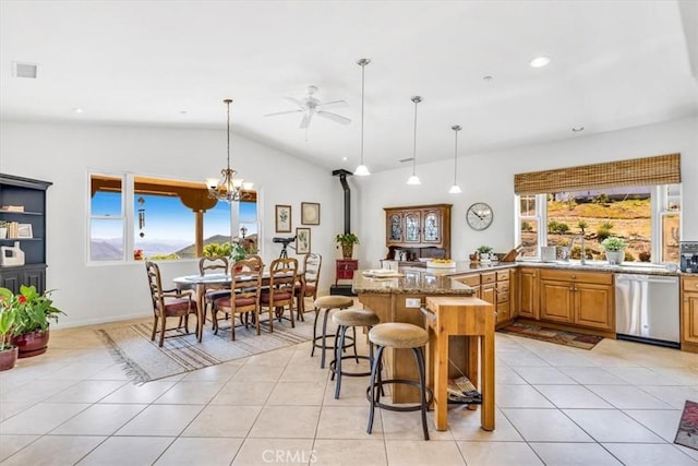 kitchen featuring a sink, a breakfast bar, visible vents, dishwasher, and vaulted ceiling
