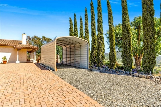 view of parking featuring gravel driveway and a detached carport