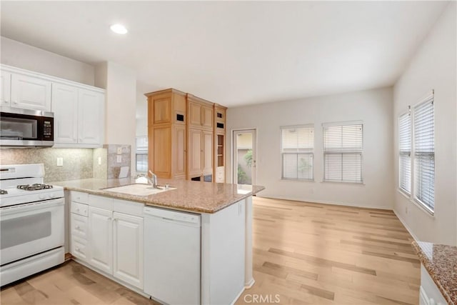 5 Chinaberry, Irvine, CA 92618 - kitchen with white appliances, a sink, a peninsula, light wood-style flooring, and white cabinetry