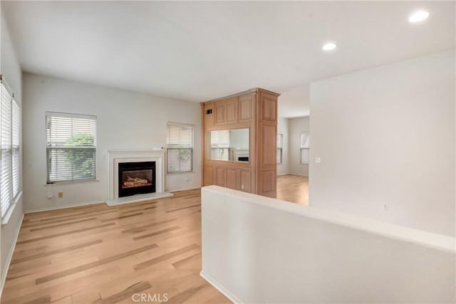 5 Chinaberry, Irvine, CA 92618 - unfurnished living room featuring light wood-type flooring, recessed lighting, a glass covered fireplace, and baseboards