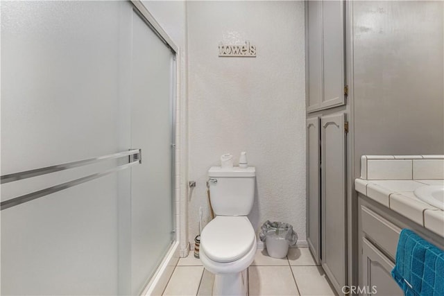 6748 Coriander Dr, Oak Hills, CA 92344 - full bathroom with vanity, toilet, tile patterned flooring, and a shower stall