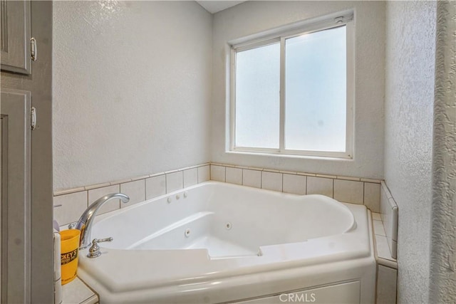 6748 Coriander Dr, Oak Hills, CA 92344 - bathroom featuring a whirlpool tub and a textured wall