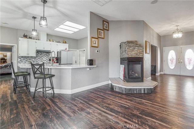 6748 Coriander Dr, Oak Hills, CA 92344 - kitchen with a breakfast bar, freestanding refrigerator, tasteful backsplash, and dark wood-style floors