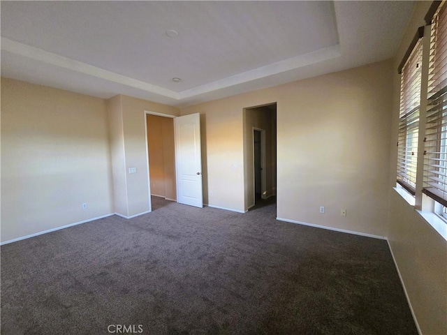 1480 Bedford Ct, Beaumont, CA 92223 - unfurnished room with dark carpet, a tray ceiling, and baseboards
