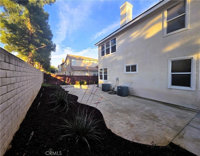 1480 Bedford Ct, Beaumont, CA 92223 - rear view of house featuring a fenced backyard, a patio, stucco siding, and a chimney