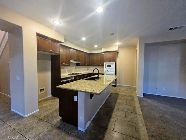 1480 Bedford Ct, Beaumont, CA 92223 - kitchen featuring built in microwave, a sink, under cabinet range hood, baseboards, and recessed lighting