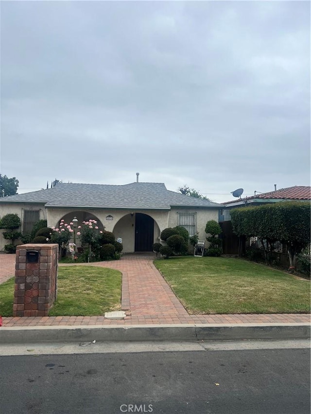 ranch-style house with stucco siding and a front lawn