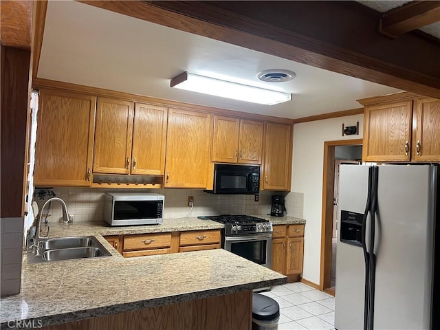 kitchen featuring a sink, a peninsula, stainless steel appliances, tasteful backsplash, and light tile patterned flooring