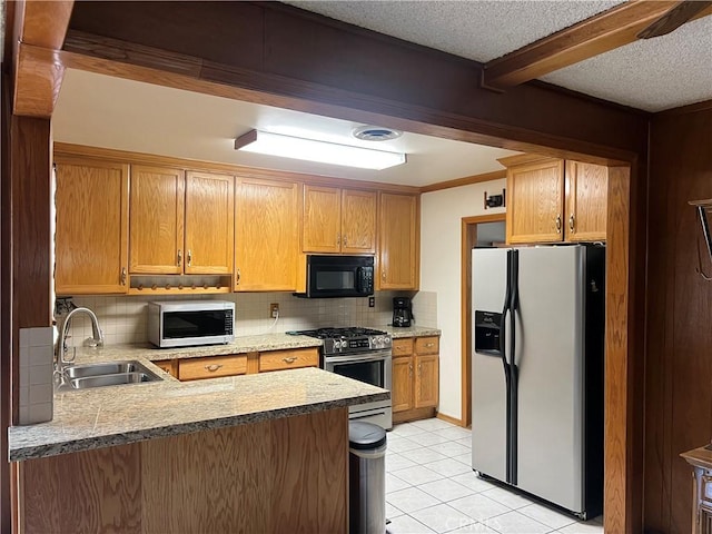 kitchen with light tile patterned flooring, a sink, a peninsula, stainless steel appliances, and tasteful backsplash