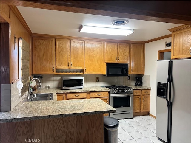 kitchen with light tile patterned floors, stainless steel appliances, tasteful backsplash, and a sink