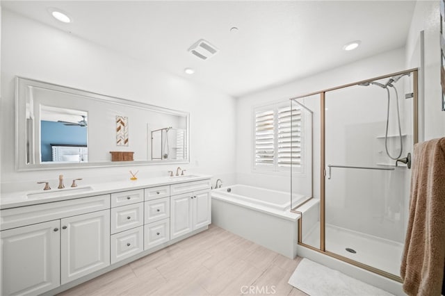 40571 Alder Ct, Temecula, CA 92591 - bathroom featuring a stall shower, double vanity, a bath, and recessed lighting