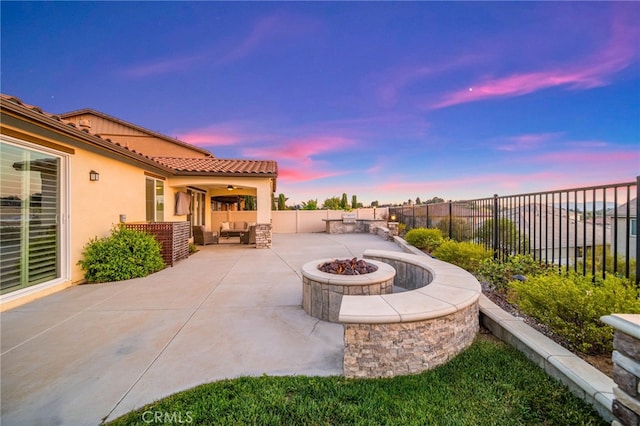 view of patio / terrace with a fenced backyard, an outdoor living space with a fire pit, and a ceiling fan