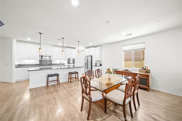 dining room featuring recessed lighting, light wood-type flooring, and baseboards