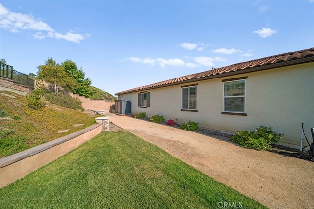 back of property featuring a tile roof and stucco siding