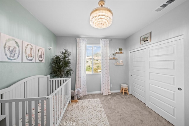 bedroom featuring carpet, a chandelier, a crib, and baseboards