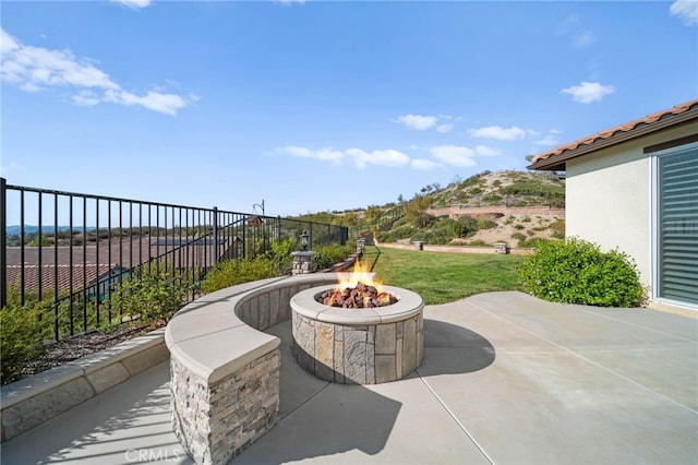 view of patio / terrace with an outdoor fire pit and fence