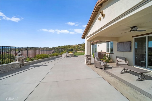 view of patio featuring fence and a ceiling fan