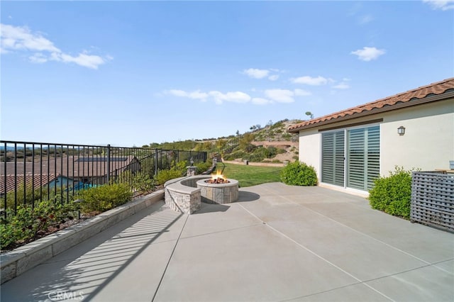 view of patio / terrace featuring an outdoor fire pit and fence